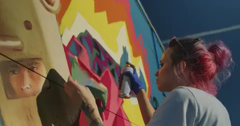 Artist spray painting a wall